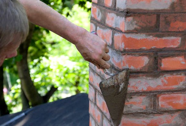 Fresh mortar packed and struck along a brick joint