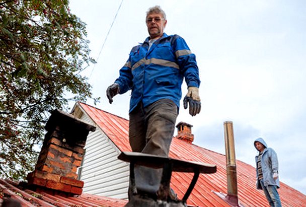 Two masons reading a chimney from the roof slope